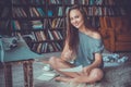 Young woman writer in library at home creative occupation looking camera smiling Royalty Free Stock Photo