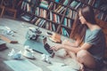 Young woman writer in library at home creative occupation pressing buttons Royalty Free Stock Photo