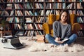 Young woman writer in library at home creative occupation sitting taking notes Royalty Free Stock Photo