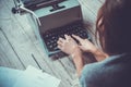 Young woman writer in library at home creative occupation typing typewriter Royalty Free Stock Photo