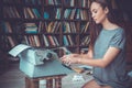 Young woman writer in library at home creative occupation writing detective Royalty Free Stock Photo