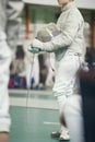 Young fencer holding rapier in his hand on the fencing tournament