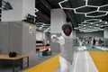 Young fencer practicing attack in training room after lesson