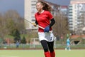 Young field hockey girl player runs with the stick