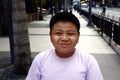 Young Filipino boy pose for the camera while at a business district