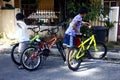 Young Filipino boys play with colorful bicycles on a bright and sunny day