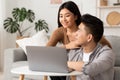 Young filipino couple using laptop at home