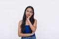 A young Filipino woman feels like a total bummer after a bad toothache. Putting her hand on her jaw. Isolated on a white Royalty Free Stock Photo