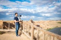 Young filmmaker filming natural landscape in canyon with a large river and marshes