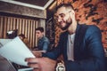 Young finance market analyst working on laptop, analyzing documents in office