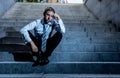 Young fired business man lost in depression crying abandoned sitting on ground street concrete stairs suffering emotional pain Royalty Free Stock Photo