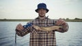 Young fisherman actively fishing at lake. Man demonstrates the caught pike Royalty Free Stock Photo