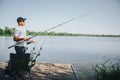 Young fisherman fishing on lake or river. Side view of adult guy fising at river or lake. Man holding rod in hands Royalty Free Stock Photo