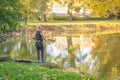 Young fisherman at lake catches fish during summer time