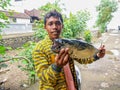A young fisherman with a tuna caught in the sea. A happy day for a young Indonesian fisherman. Tasty fish with delicate meat. Sunn Royalty Free Stock Photo