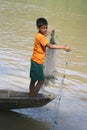 Child labor, young fishing boy in action at mekong river in Laos Royalty Free Stock Photo