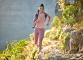 Young fit and active african american woman hiking and jogging through the mountains on a sunny summer day. Black woman Royalty Free Stock Photo