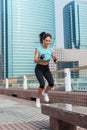 Young fit active woman bench jump squat jumping on city street. Fitness girl doing exercises outdoors. Royalty Free Stock Photo