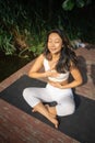 Young fit asian woman doing yoga by the lake in the morning park Royalty Free Stock Photo