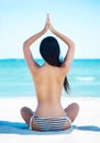 Young, fit and beautiful girl meditating on a summer beach Royalty Free Stock Photo