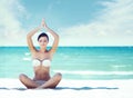 Young, fit and beautiful girl meditating on a summer beach Royalty Free Stock Photo