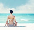 Young, fit and beautiful girl meditating on a summer beach Royalty Free Stock Photo