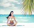 Young, fit and beautiful girl meditating on a summer beach Royalty Free Stock Photo