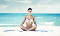 Young, fit and beautiful girl meditating on a summer beach Royalty Free Stock Photo