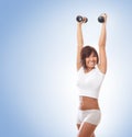 A young and fit brunette training with dumbbells Royalty Free Stock Photo
