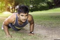 Young fit Caucasian man doing push-ups outdoors on sunny summer day. Fitness and sport lifestyle concept. Royalty Free Stock Photo