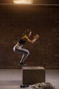 Side view image of fit young woman doing a box jump exercise. Royalty Free Stock Photo