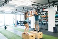 Young fit couple exercising in gym, doing box jumps. Royalty Free Stock Photo