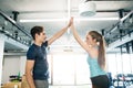 Young fit couple exercising in gym, giving high five each other. Royalty Free Stock Photo
