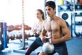 Young fit couple in gym exercising with kettlebell. Royalty Free Stock Photo