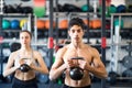Young fit couple in gym exercising with kettlebell. Royalty Free Stock Photo