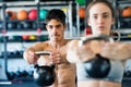 Young fit couple in gym exercising with kettlebell. Royalty Free Stock Photo