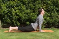 Young fit male practicing yoga and doing the cobra pose outdoors Royalty Free Stock Photo