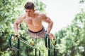 Young fit man doing push ups on bars Royalty Free Stock Photo