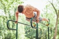 Young fit man doing push ups on bars Royalty Free Stock Photo