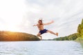 Young fit man making a jump into a lake. Royalty Free Stock Photo