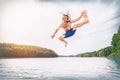 Young fit man making a jump into a lake. Royalty Free Stock Photo