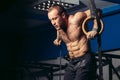 Fit man pulling up on gymnastic rings. Royalty Free Stock Photo