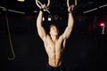 Young fit man pulling up on gymnastic rings. Royalty Free Stock Photo