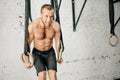 Fit man pulling up on gymnastic rings. Royalty Free Stock Photo