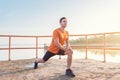 Young fit man stretching legs outdoors doing forward lunge. Royalty Free Stock Photo