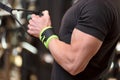 Young fit muscular man close up doing triceps pull down rope extension exercise in modern fitness center. Royalty Free Stock Photo