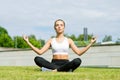 Young, fit and sporty woman doing yoga exercise meditation in the park. Fitness, sport, urban and healthy lifestyle Royalty Free Stock Photo