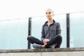 Young, fit and sporty woman sitting on a concrete border. Fitness, sport, urban jogging and healthy lifestyle concept. Royalty Free Stock Photo