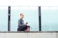 Young, fit and sporty girl sitting on a concrete border. Fitness, sport, urban jogging and healthy lifestyle concept. Royalty Free Stock Photo