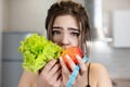 Young fit woman with centimeter round neck holding green salad and apple dietology and nutrition